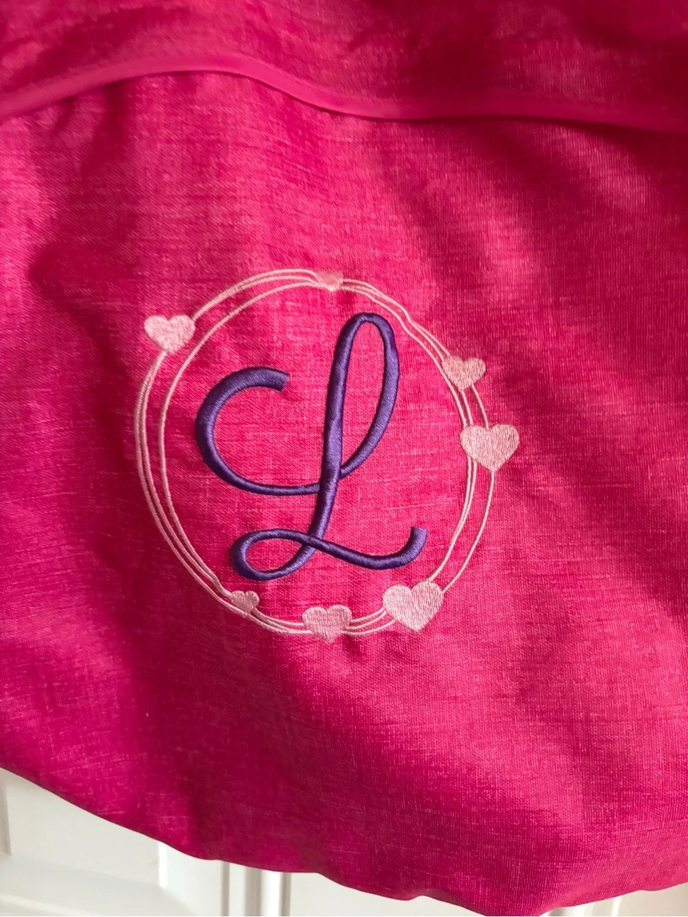 Cute personalized drawstring backpack in a vibrant pink fabric, letter L